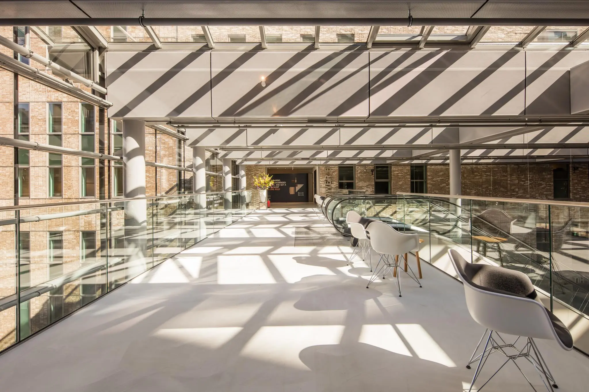 Lichte en moderne binnenruimte aan de Prinses Beatrixlaan met glazen dak, zithoek en roltrap.